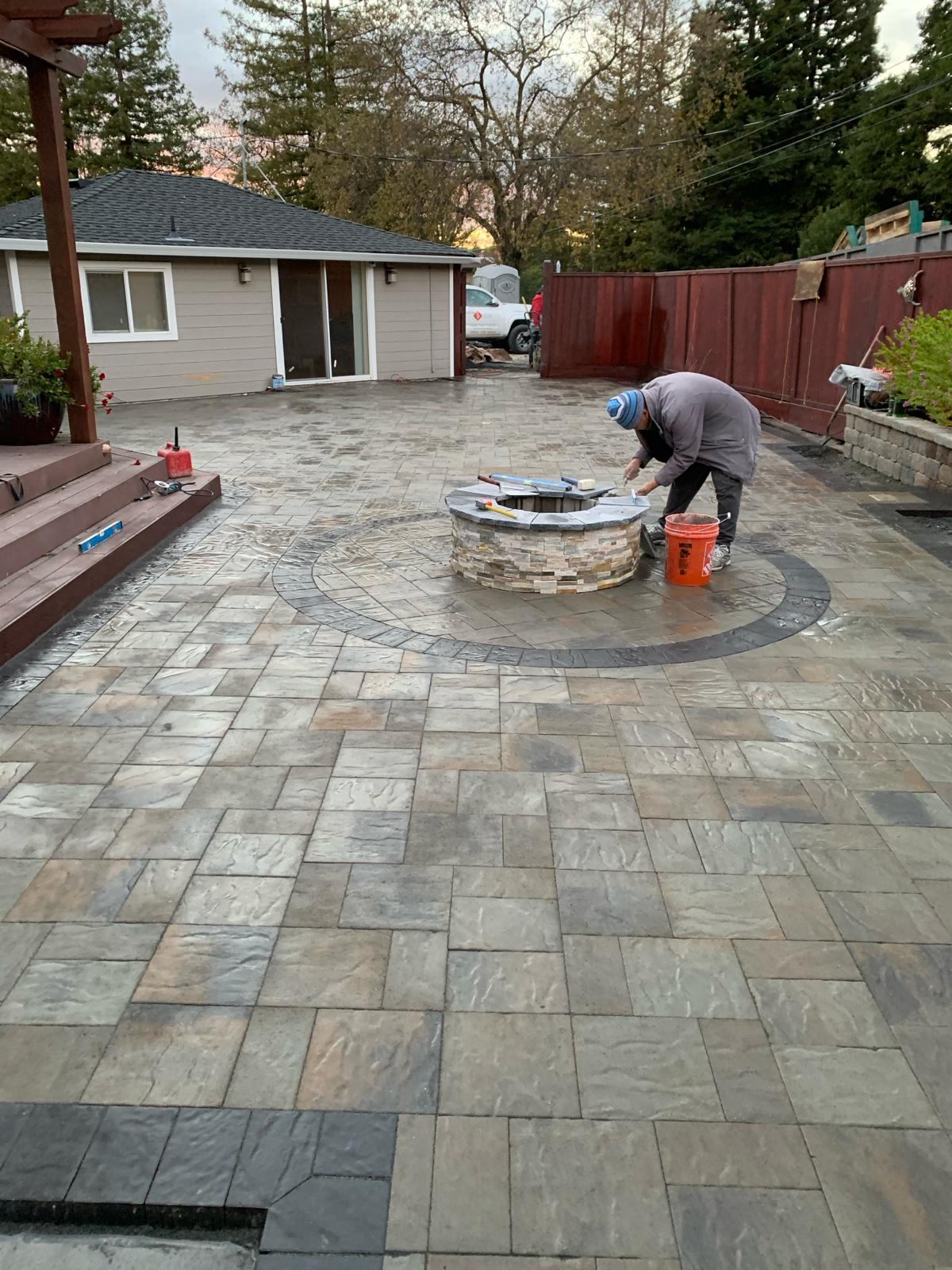 Crew finishing a paver patio fire pit
